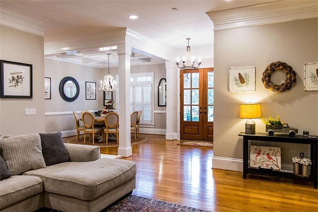 living room featuring a chandelier, crown molding, wood finished floors, baseboards, and recessed lighting