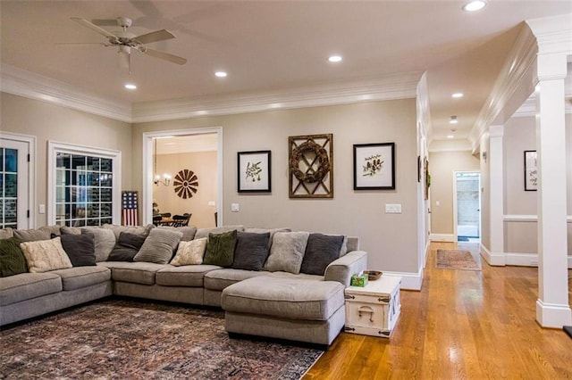 living room featuring light wood-type flooring, ornamental molding, ceiling fan, recessed lighting, and baseboards