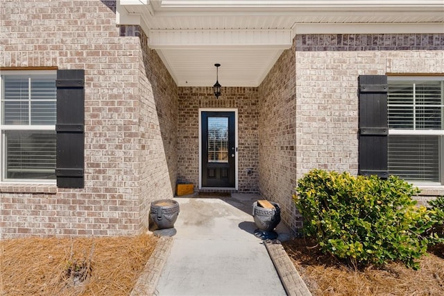 view of exterior entry featuring brick siding