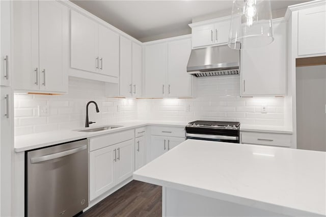 kitchen with white cabinets, sink, stainless steel appliances, and wall chimney range hood