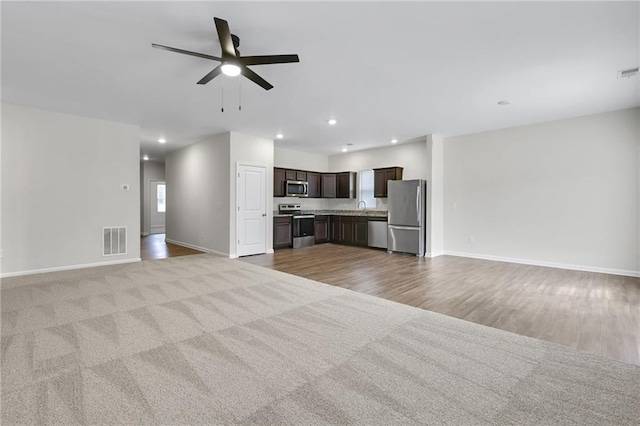 unfurnished living room with ceiling fan and sink