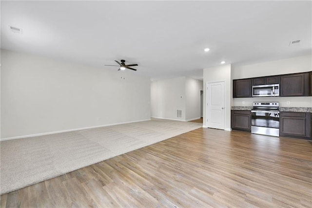 unfurnished living room featuring ceiling fan and light hardwood / wood-style flooring