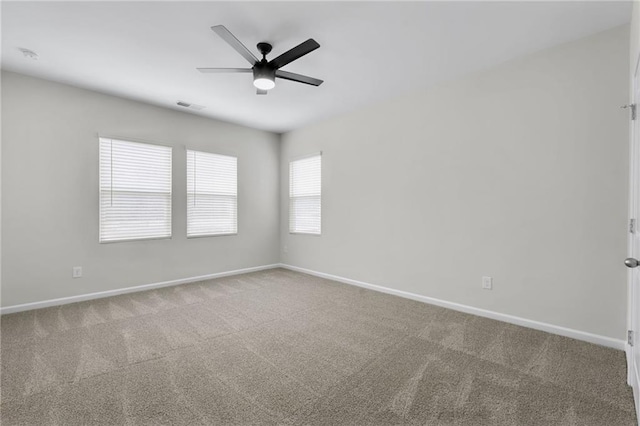 unfurnished room with ceiling fan and carpet