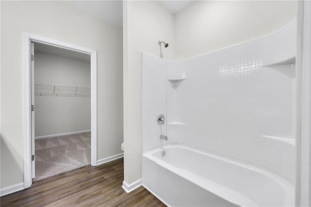 bathroom featuring hardwood / wood-style flooring, bathtub / shower combination, and toilet