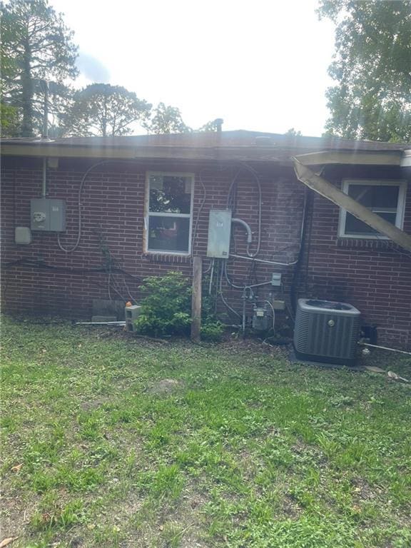914 Bowden St, Savannah, GA 31415 - view of front of property with central air condition unit, brick siding, and a front lawn