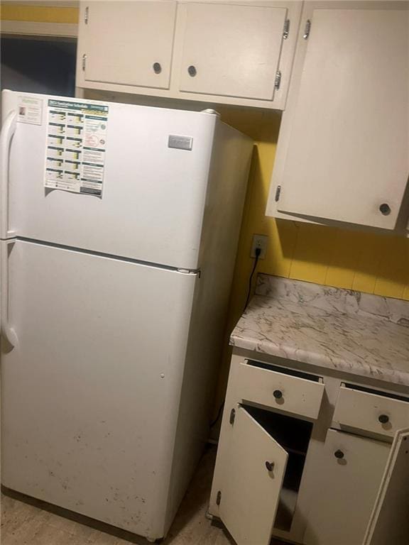 914 Bowden St, Savannah, GA 31415 - kitchen with freestanding refrigerator, white cabinetry, and light countertops