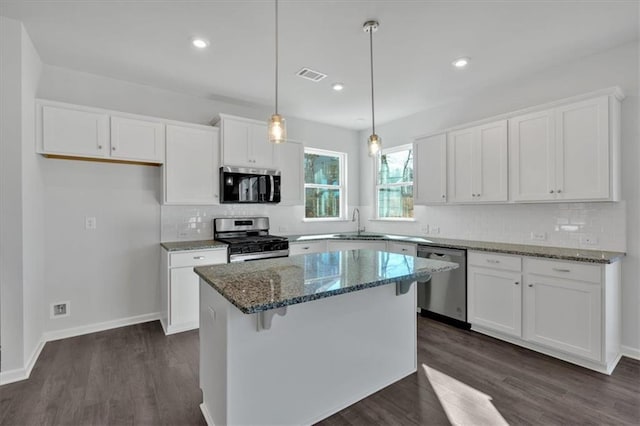 14 Grove Pointe Way SE, Cartersville, GA 30120 - kitchen featuring dark wood-style flooring, stainless steel appliances, visible vents, white cabinets, and a kitchen island