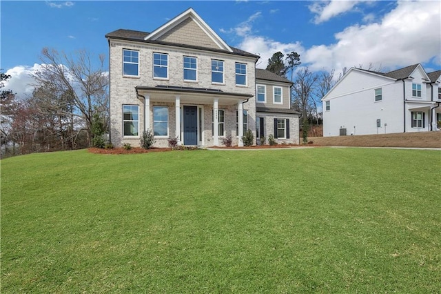 view of front of home with a front lawn and brick siding