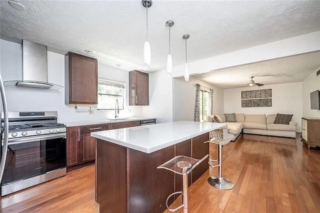 1202 Laurel Cliff Dr SE, Smyrna, GA 30082 - kitchen with stainless steel gas range oven, wall chimney exhaust hood, a sink, open floor plan, and a breakfast bar