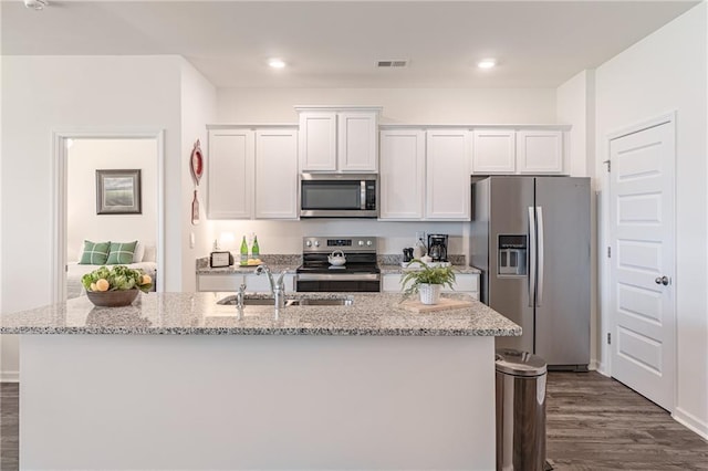 2010 Vidalia Ct, Dacula, GA 30019 - kitchen featuring stainless steel appliances, a sink, dark wood-style floors, white cabinets, and an island with sink
