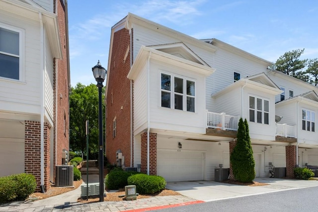 623 Brennan Dr, Decatur, GA 30033 - view of home's exterior with central AC, a garage, brick siding, and concrete driveway