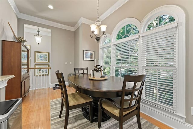 dining area with light wood finished floors, crown molding, a chandelier, and recessed lighting