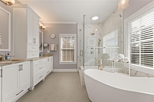 full bath featuring a marble finish shower, healthy amount of natural light, vanity, and ornamental molding