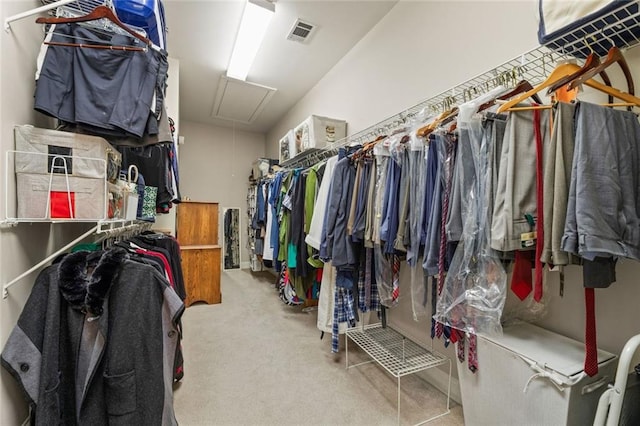 walk in closet with attic access and carpet floors