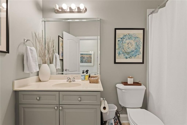 bathroom featuring toilet, vanity, and a shower with shower curtain