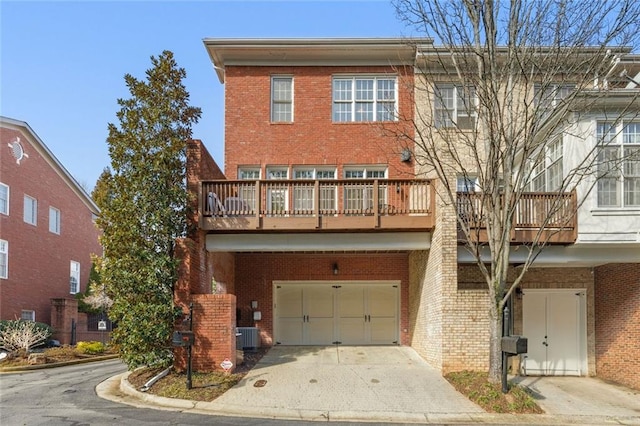 view of front of house with an attached garage, a balcony, brick siding, driveway, and cooling unit