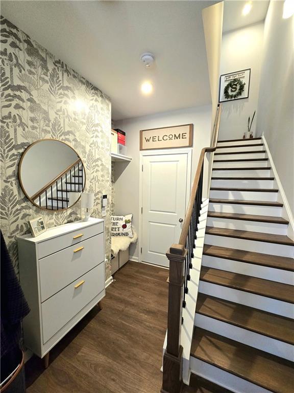 interior space with baseboards, wood finished floors, and wallpapered walls