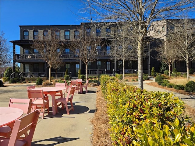 view of home's community with outdoor dining area and a patio