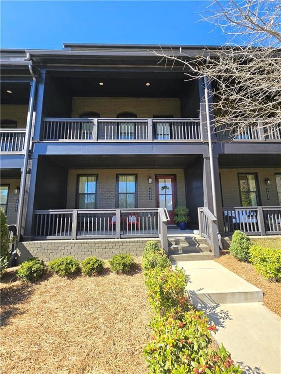 view of front facade with covered porch and brick siding