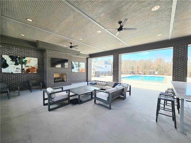 view of patio featuring a fenced in pool, an outdoor living space with a fireplace, and a ceiling fan