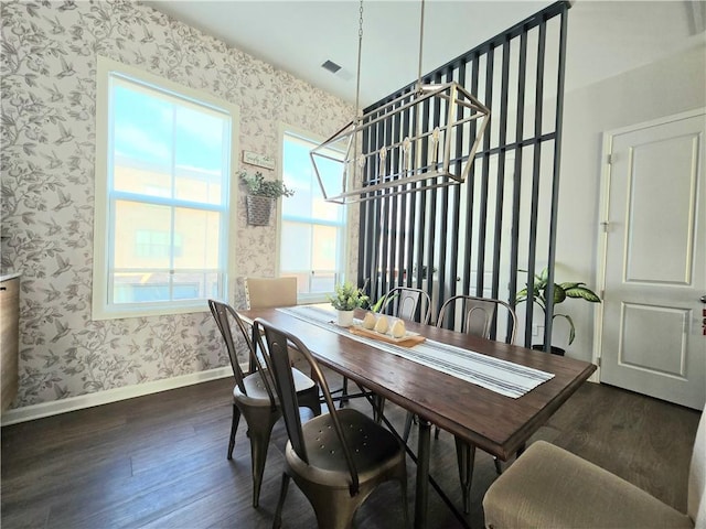 dining space featuring wallpapered walls, baseboards, and dark wood finished floors