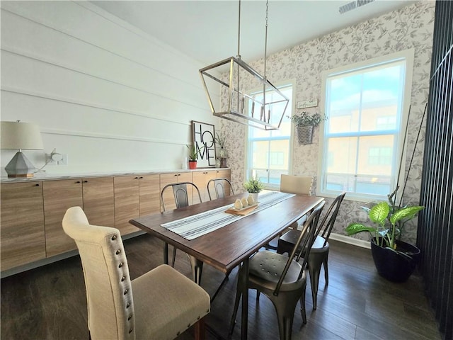 dining space with wallpapered walls, baseboards, and dark wood-type flooring