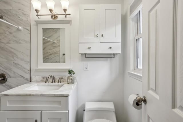 bathroom featuring vanity, toilet, and walk in shower