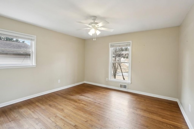 spare room with hardwood / wood-style flooring, plenty of natural light, and ceiling fan