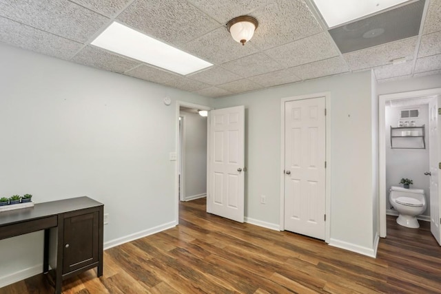 bedroom with dark hardwood / wood-style flooring, ensuite bath, and a paneled ceiling