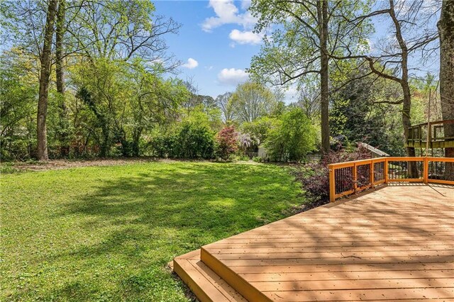 back of property with a lawn and a deck