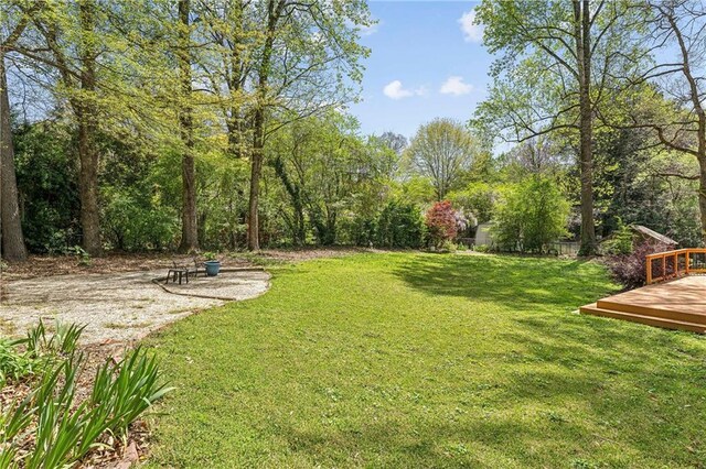 back of house featuring a deck and a lawn