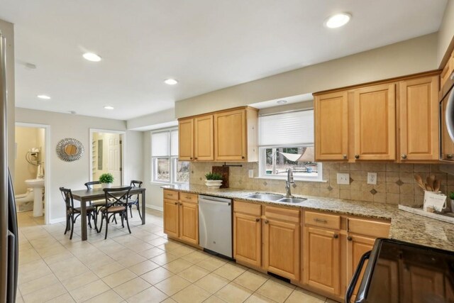 kitchen with backsplash, stainless steel appliances, sink, and light tile patterned floors