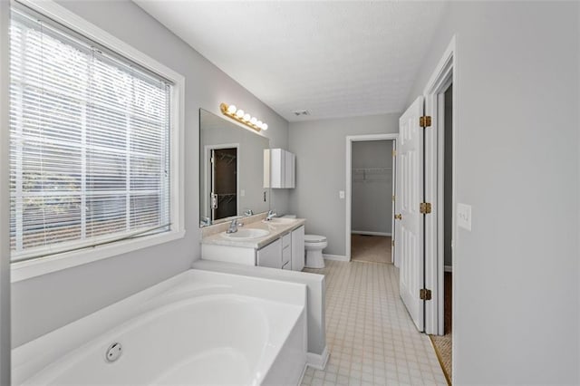 bathroom with a bathing tub, toilet, and vanity