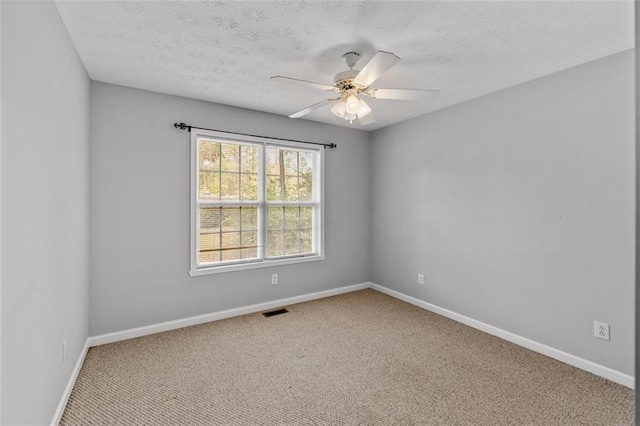 unfurnished room featuring a textured ceiling, carpet, and ceiling fan