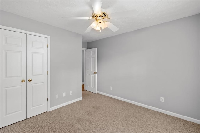 unfurnished bedroom with light carpet, a closet, and ceiling fan