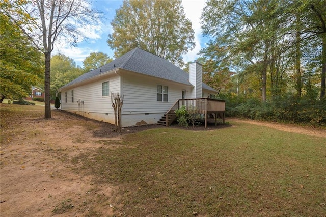 view of side of property featuring a wooden deck and a lawn