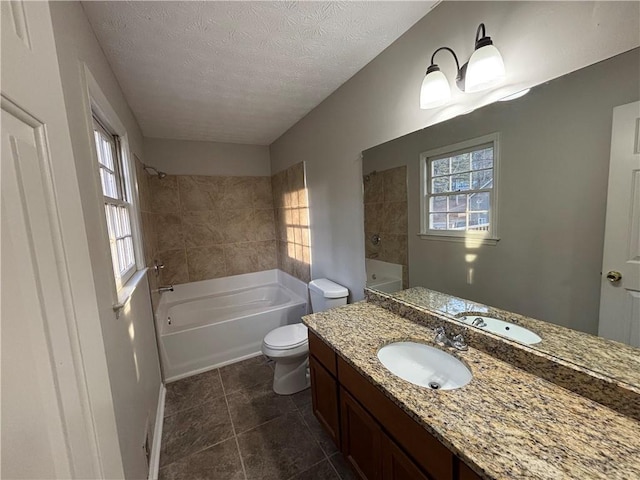 bathroom featuring vanity, a healthy amount of sunlight, toilet, and a textured ceiling