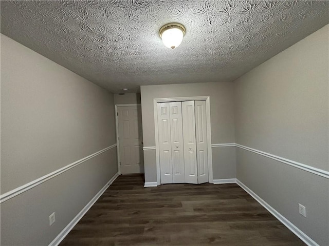 unfurnished bedroom with dark hardwood / wood-style flooring, a closet, and a textured ceiling