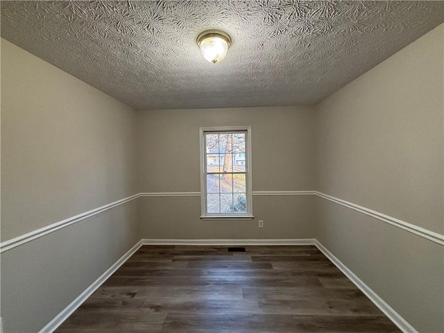 unfurnished room featuring dark hardwood / wood-style floors and a textured ceiling