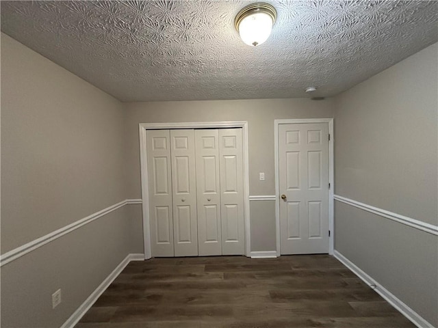 unfurnished bedroom featuring dark wood-type flooring, a closet, and a textured ceiling