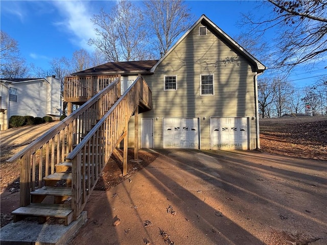 back of house featuring a garage and a deck