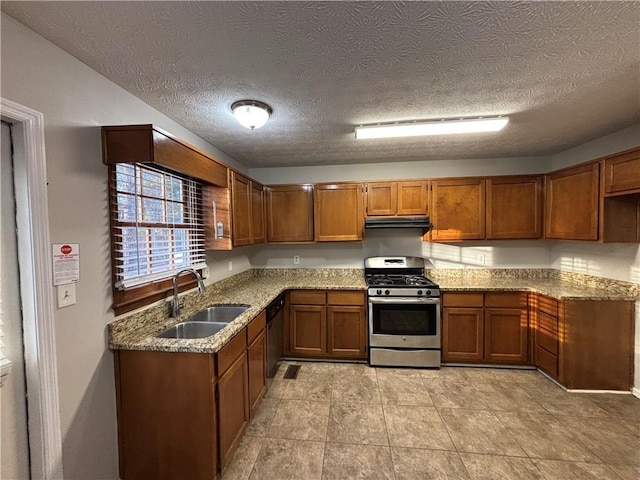 kitchen with light stone counters, appliances with stainless steel finishes, and sink