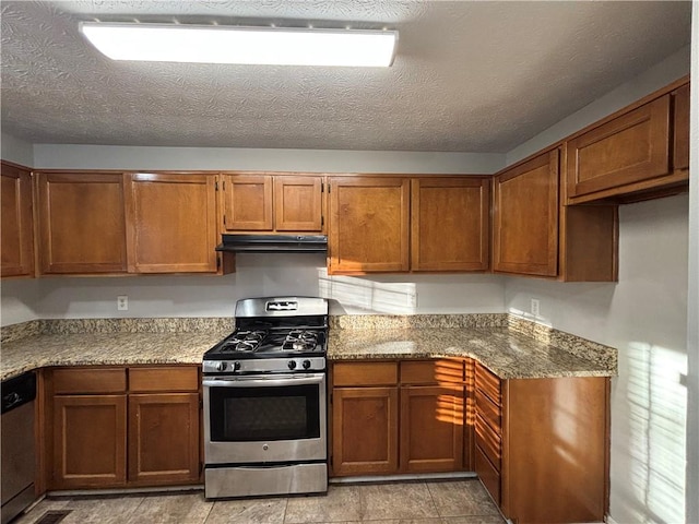 kitchen featuring ventilation hood, appliances with stainless steel finishes, a textured ceiling, and light stone counters