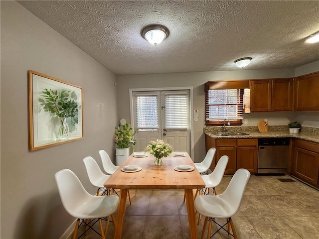 dining room featuring french doors, sink, and a textured ceiling