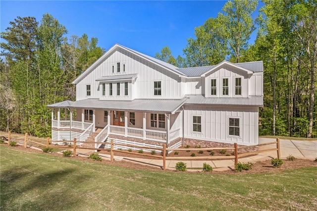 back of property with covered porch and a lawn