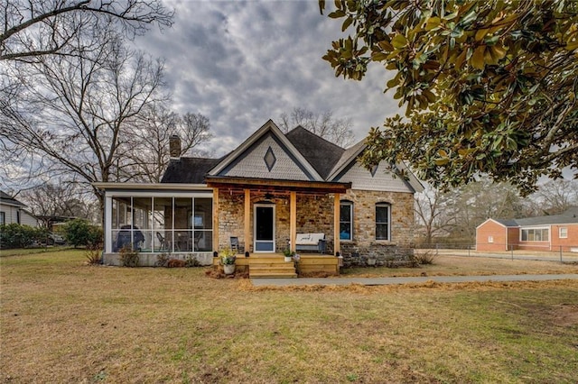 view of front of property with a sunroom and a front yard