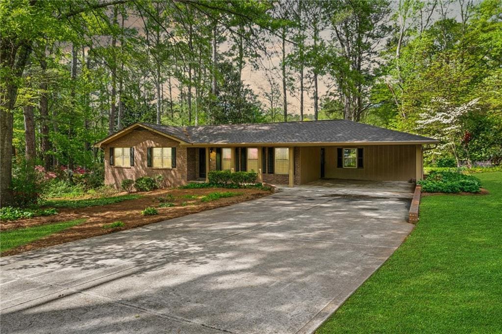 1061 Pathfinder Rd, Marietta, GA 30066 - ranch-style house with an attached carport, a front yard, and concrete driveway