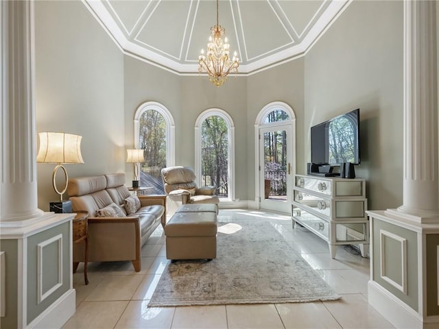 interior space with light tile patterned floors, an inviting chandelier, crown molding, and ornate columns