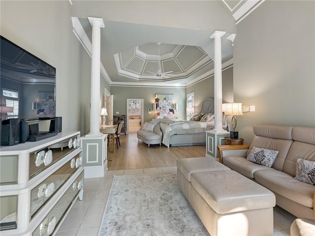 bedroom with light tile patterned floors, crown molding, and decorative columns