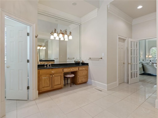 bathroom with tile patterned floors, vanity, crown molding, and baseboards